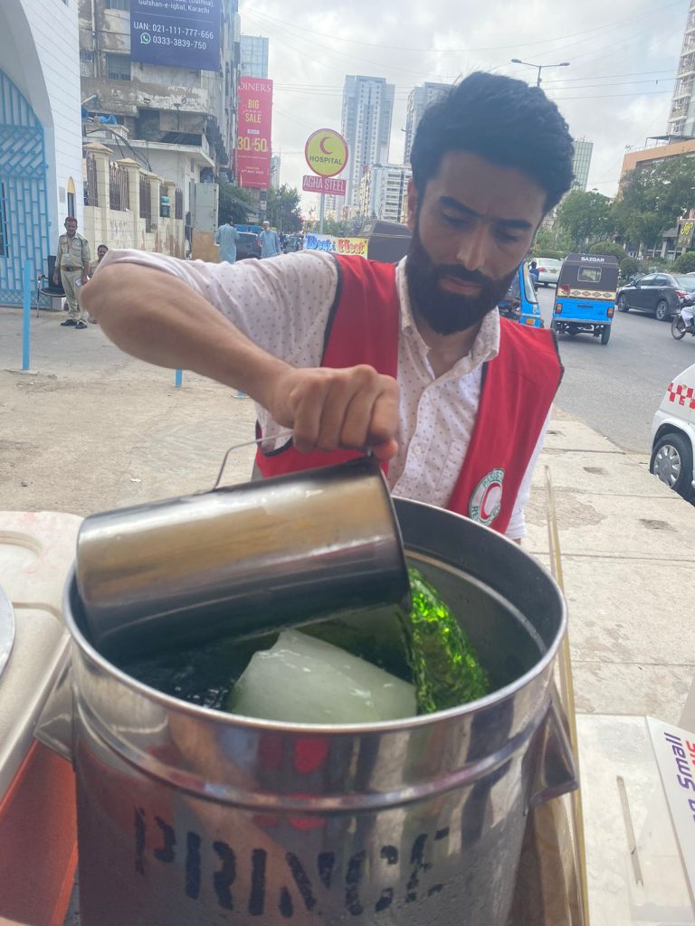 PRCS volunteers distributing clean drinking water during heatwave relief camp in Karachi