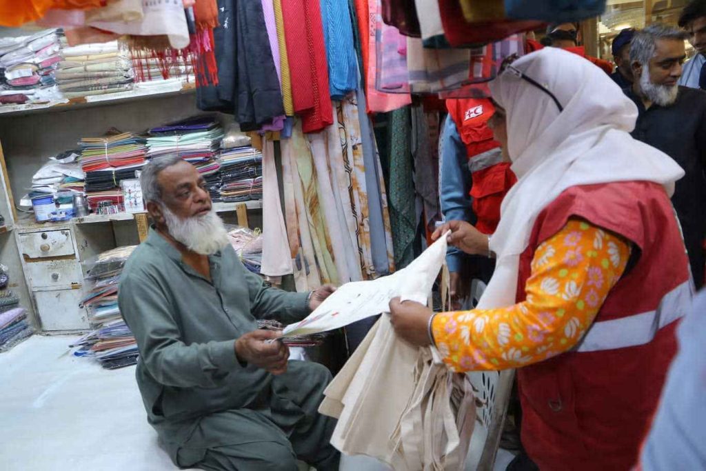 Shopkeepers receiving reusable bags from PRCS volunteers