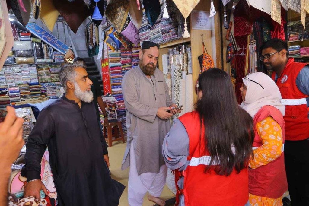 Shopkeepers receiving reusable bags from PRCS volunteers